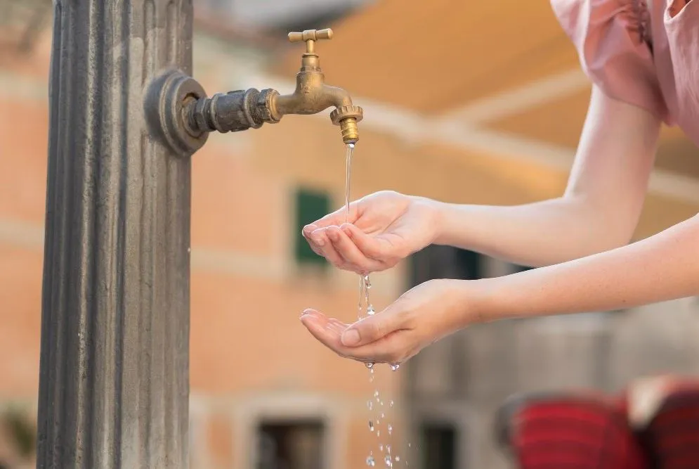 Vrouw die water drinkt bij een fontein