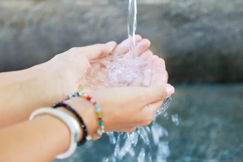 Handen van een vrouw met opspattend water